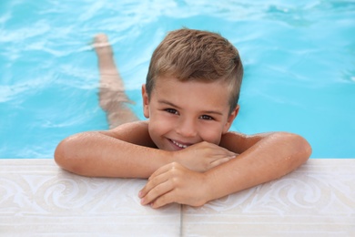 Photo of Cute little boy in outdoor swimming pool