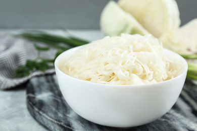 Photo of Tasty fermented cabbage on light grey table, closeup