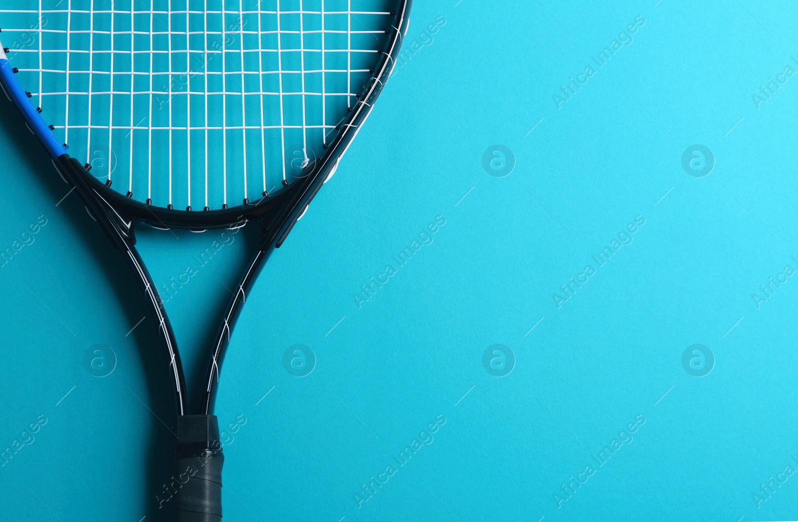 Photo of Tennis racket on blue background, top view. Space for text