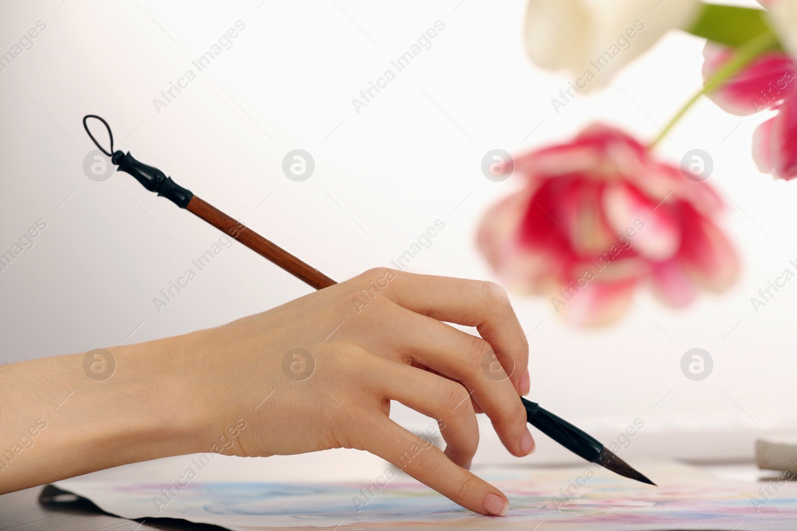 Photo of Woman painting with watercolor at wooden table indoors, closeup