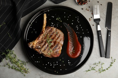 Flat lay composition with grilled meat steak on grey table