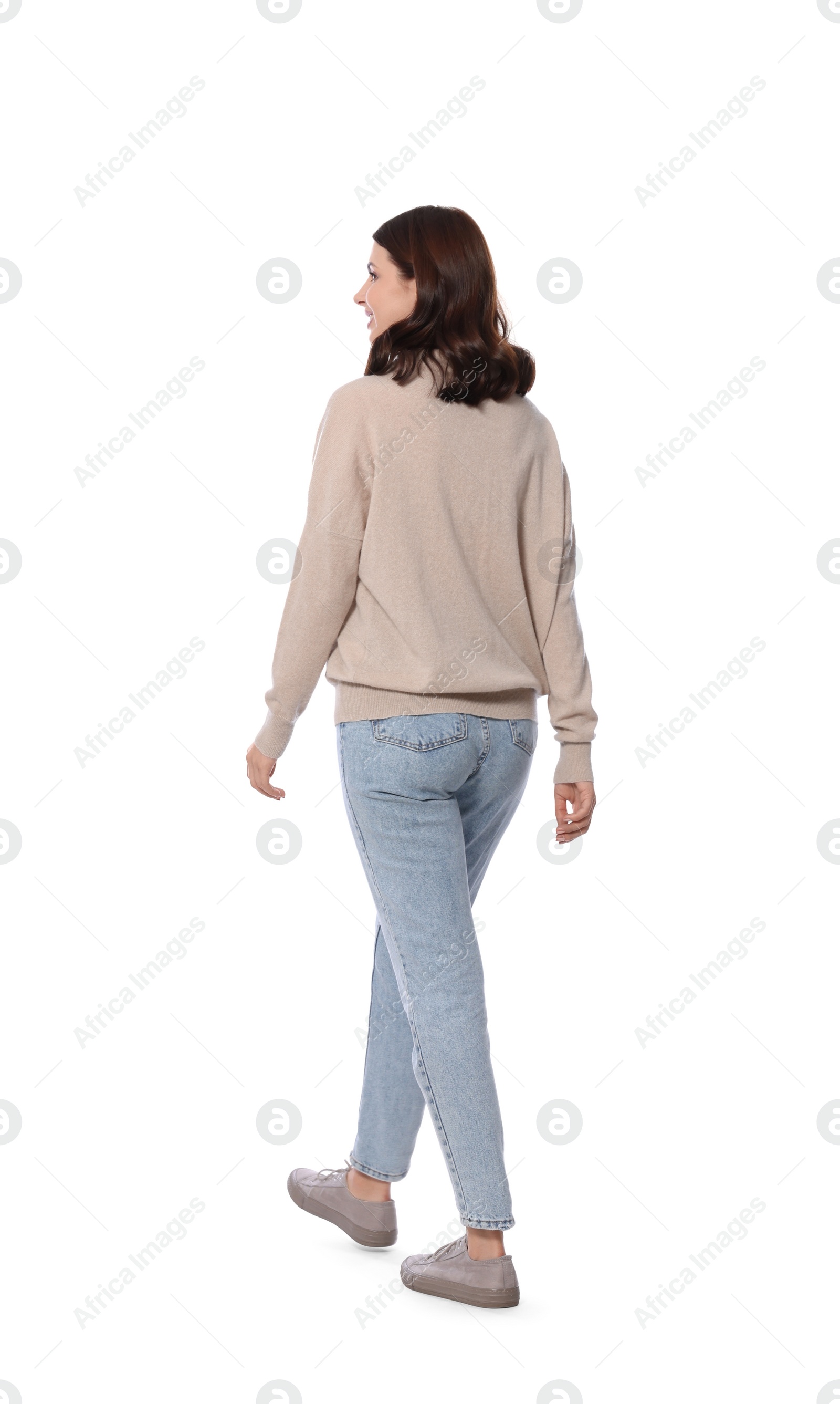 Photo of Beautiful young woman in casual outfit walking on white background