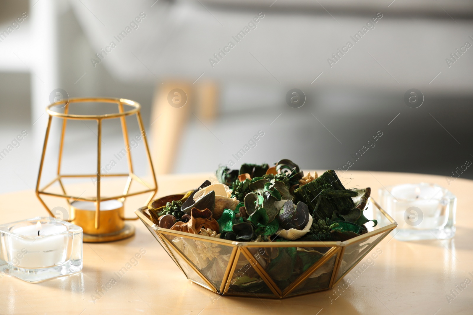 Photo of Aromatic potpourri of dried flowers in bowl on wooden table indoors