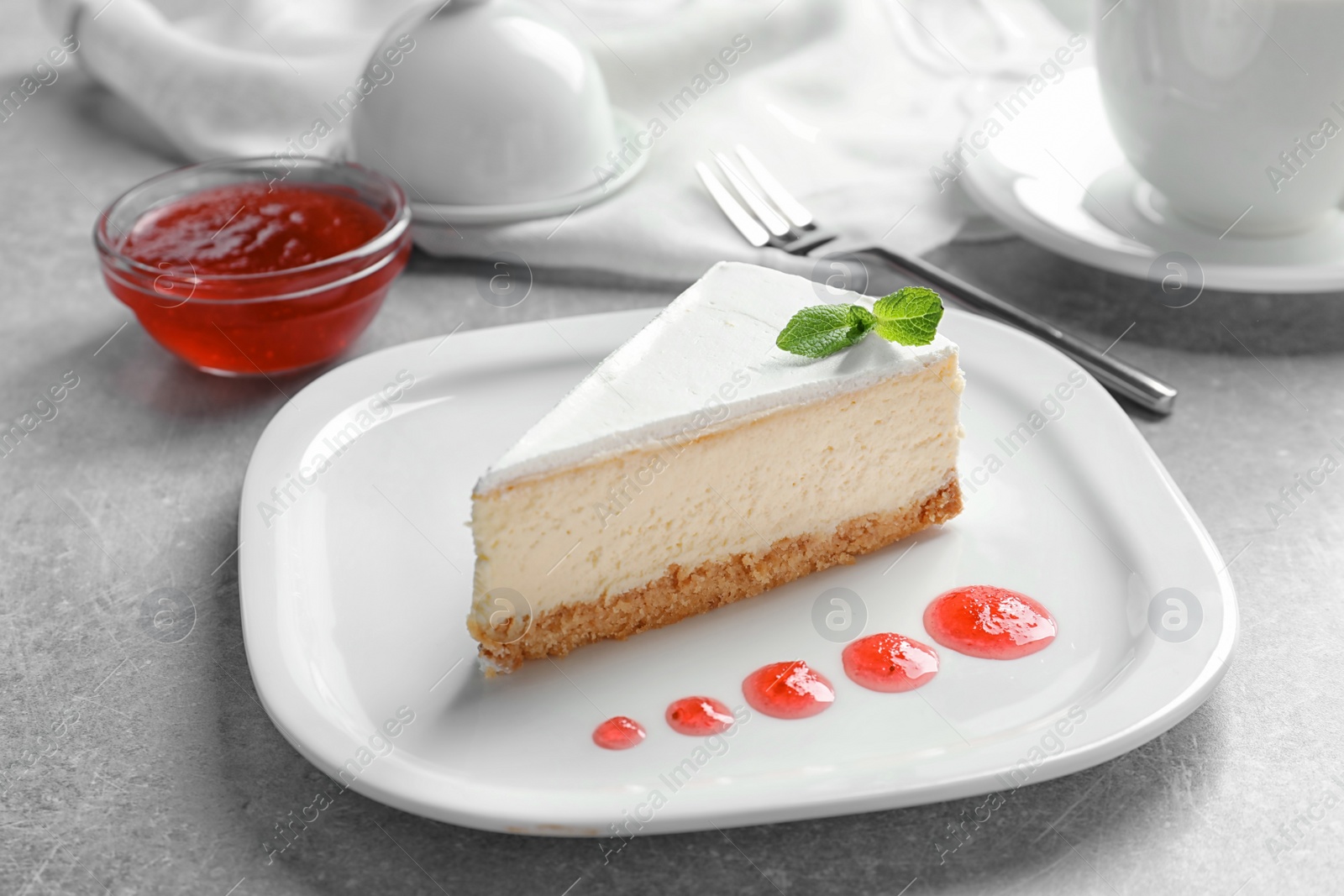 Photo of Delicious cheesecake served with sweet jam on plate