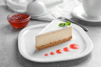 Photo of Delicious cheesecake served with sweet jam on plate