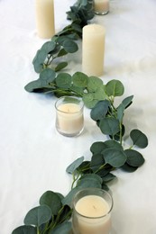 Photo of Beautiful table setting with eucalyptus branches and candles