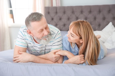 Photo of Mature couple together on bed at home