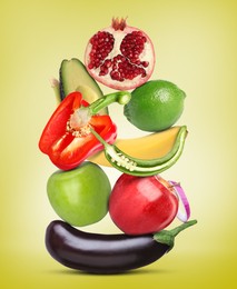 Stack of different vegetables and fruits on yellow background
