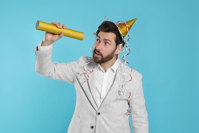 Photo of Handsome man with party popper on light blue background