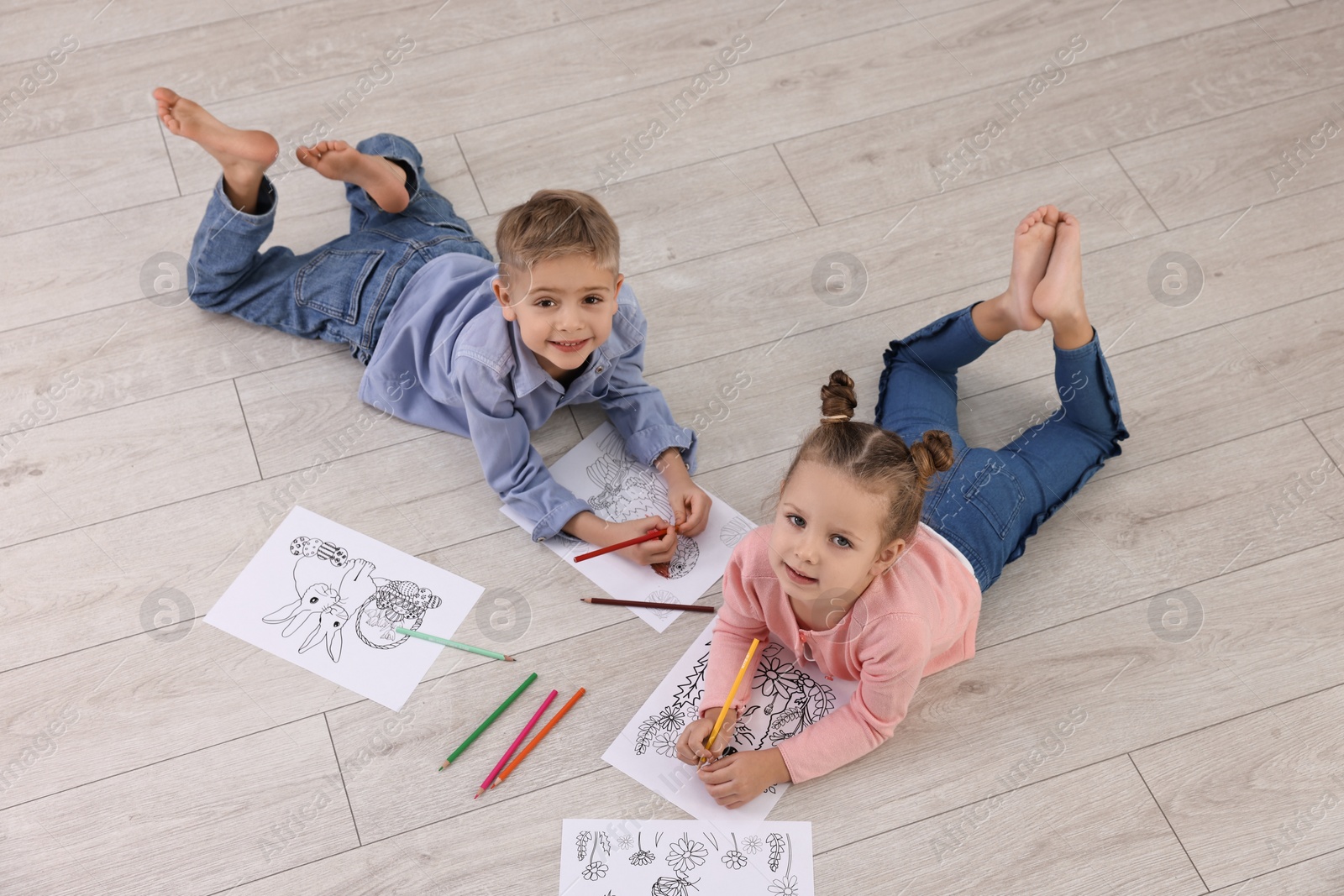 Photo of Cute little children coloring on warm floor at home. Heating system