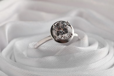 Beautiful engagement ring in white fabric, closeup view