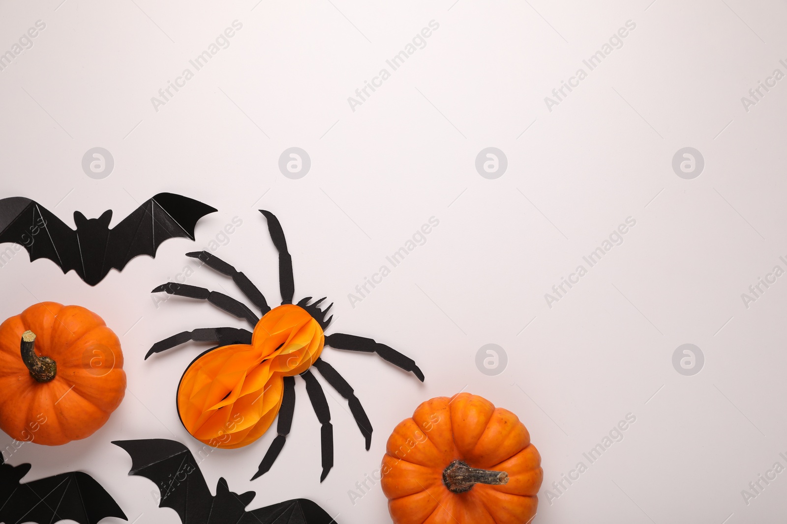 Photo of Cardboard bats, pumpkins and spider on white background, flat lay with space for text. Halloween celebration