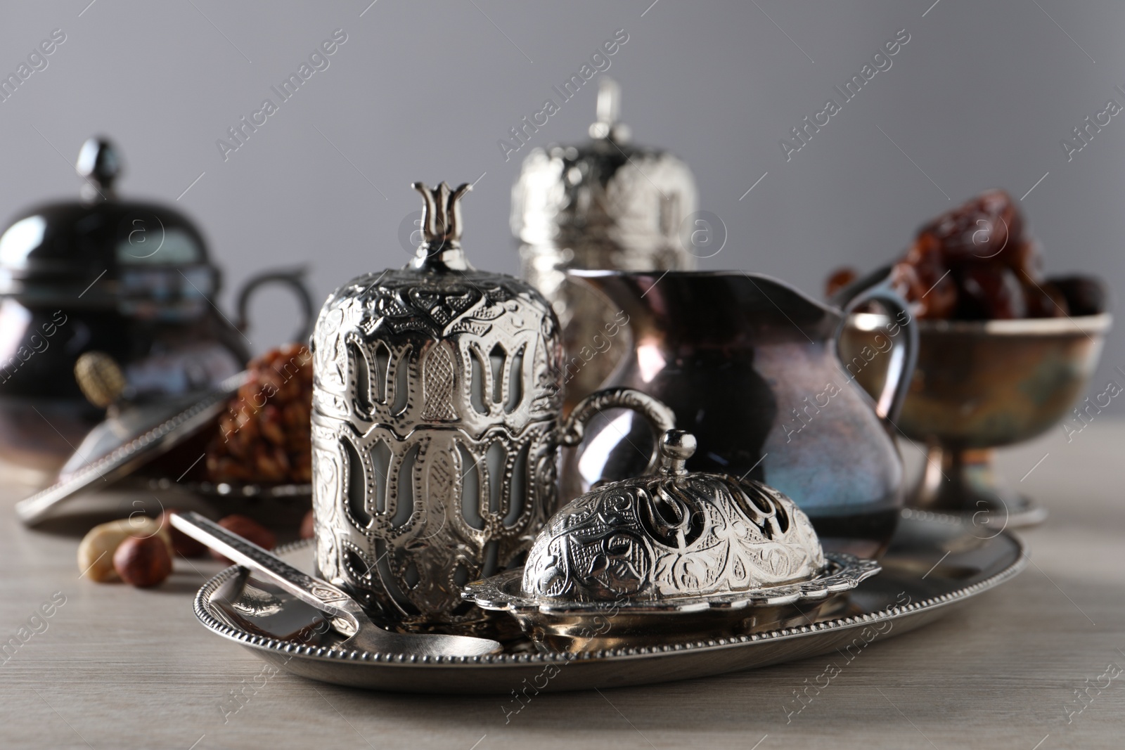 Photo of Tea, date fruits and Turkish delight served in vintage tea set on wooden table