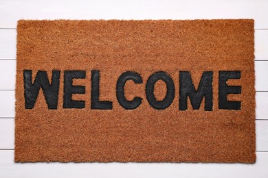 Photo of New clean mat with word WELCOME on floor, top view