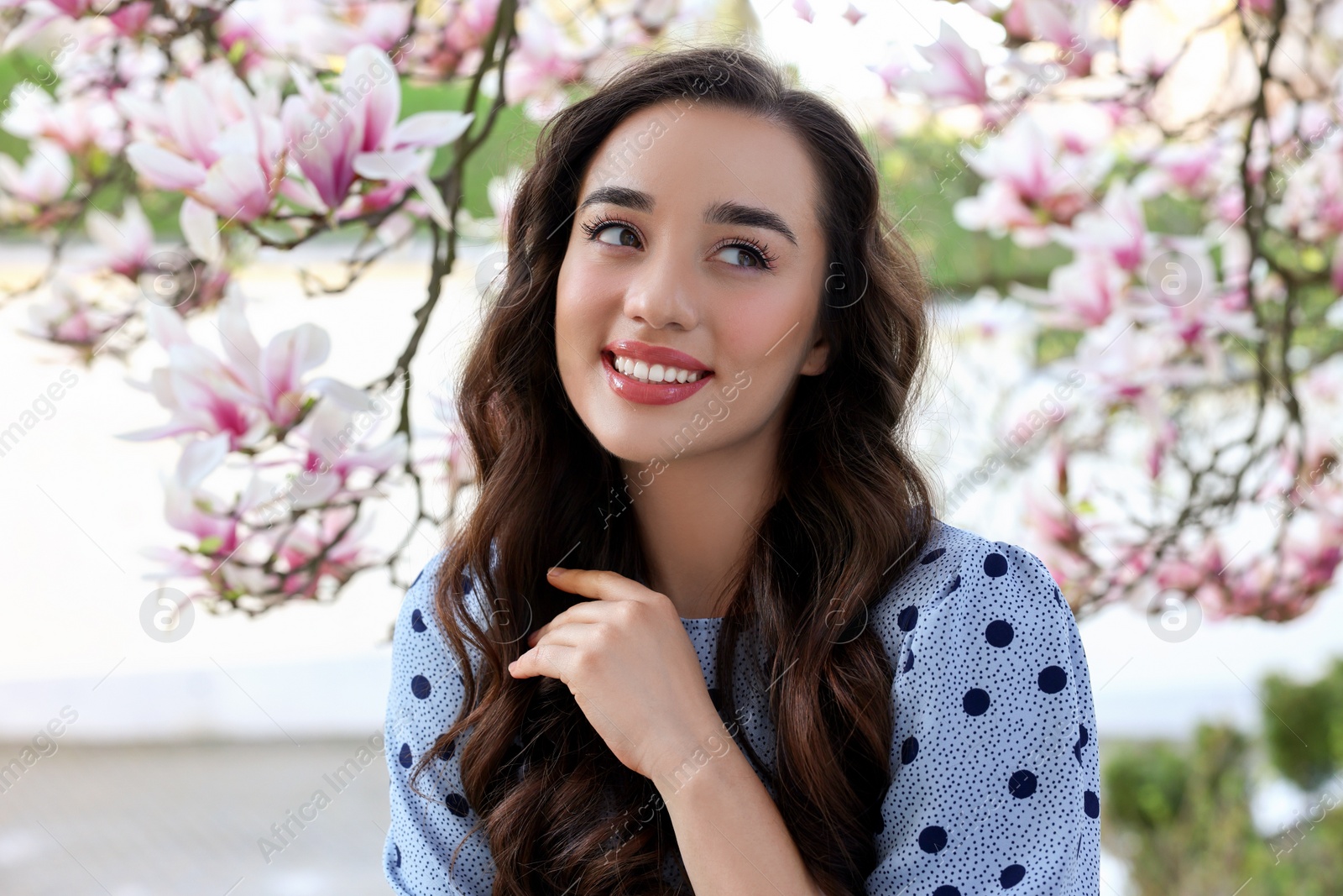 Photo of Beautiful woman near blossoming magnolia tree on spring day