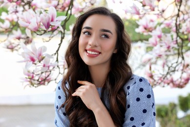 Photo of Beautiful woman near blossoming magnolia tree on spring day