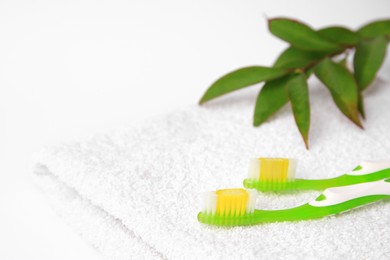 Photo of Light green toothbrushes on white terry towel