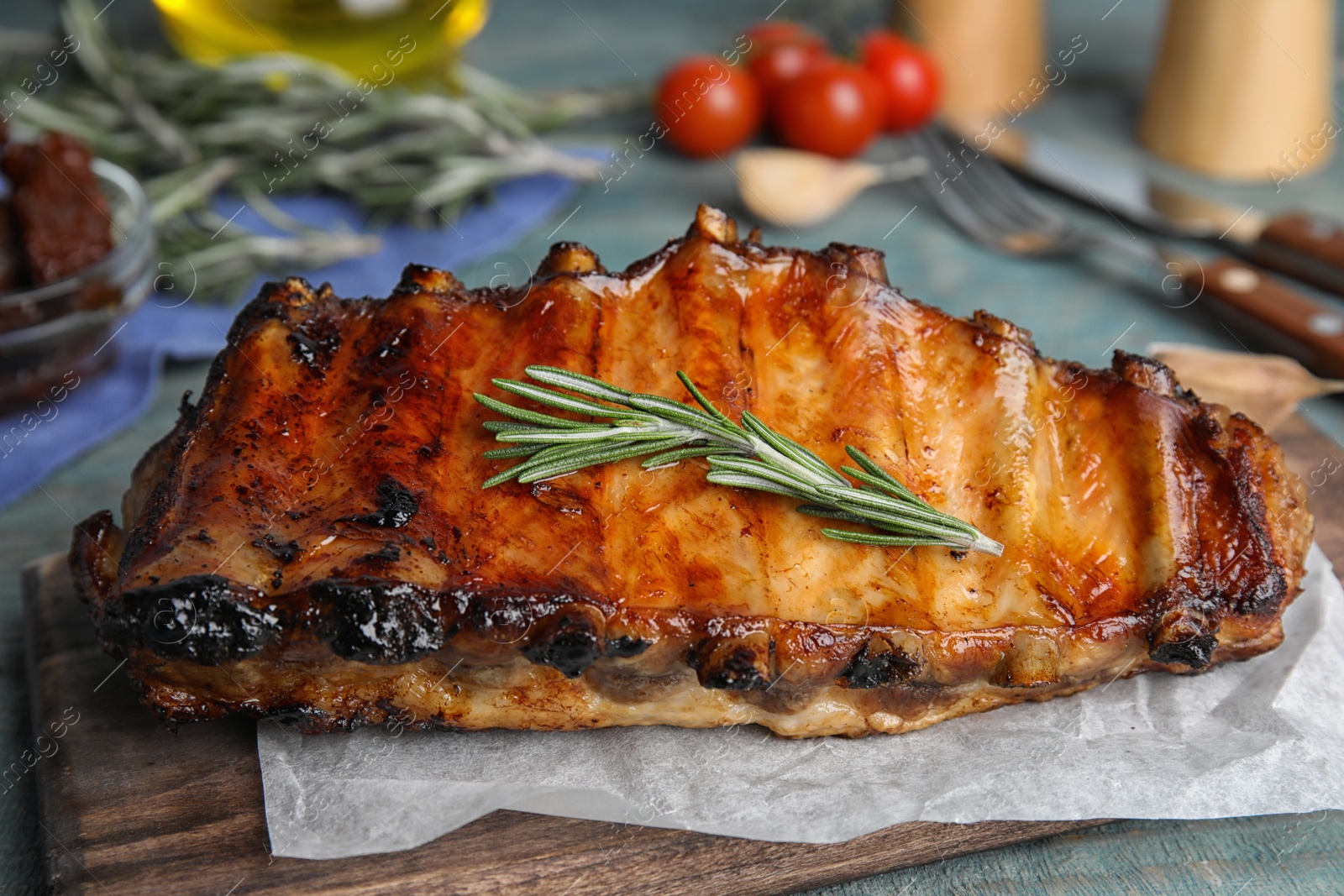 Photo of Tasty grilled ribs with rosemary on table