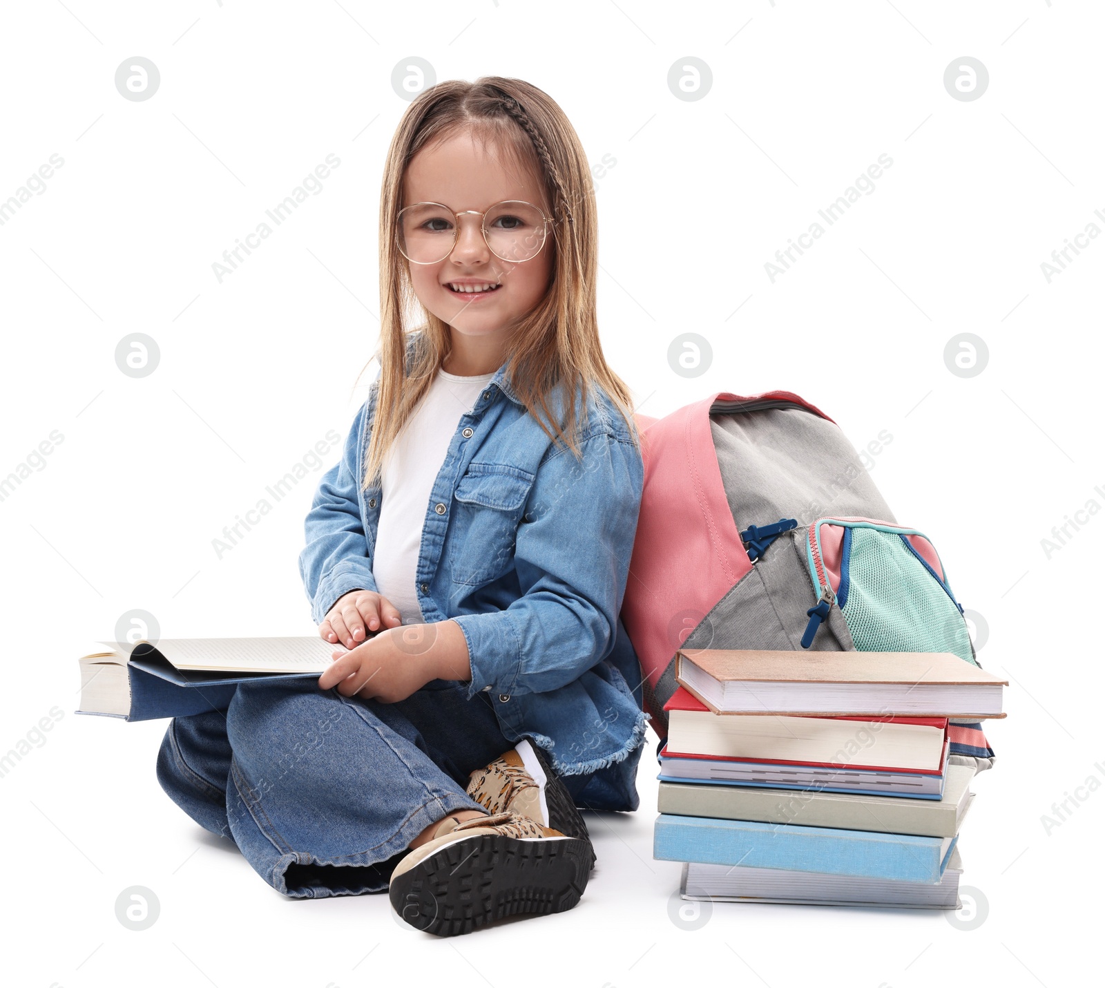 Photo of Cute little girl with books and backpack on white background