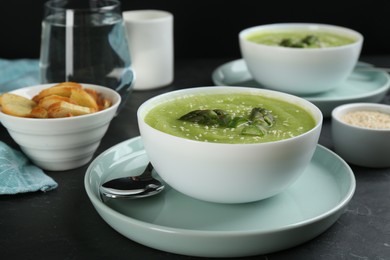 Photo of Delicious asparagus soup served on black table