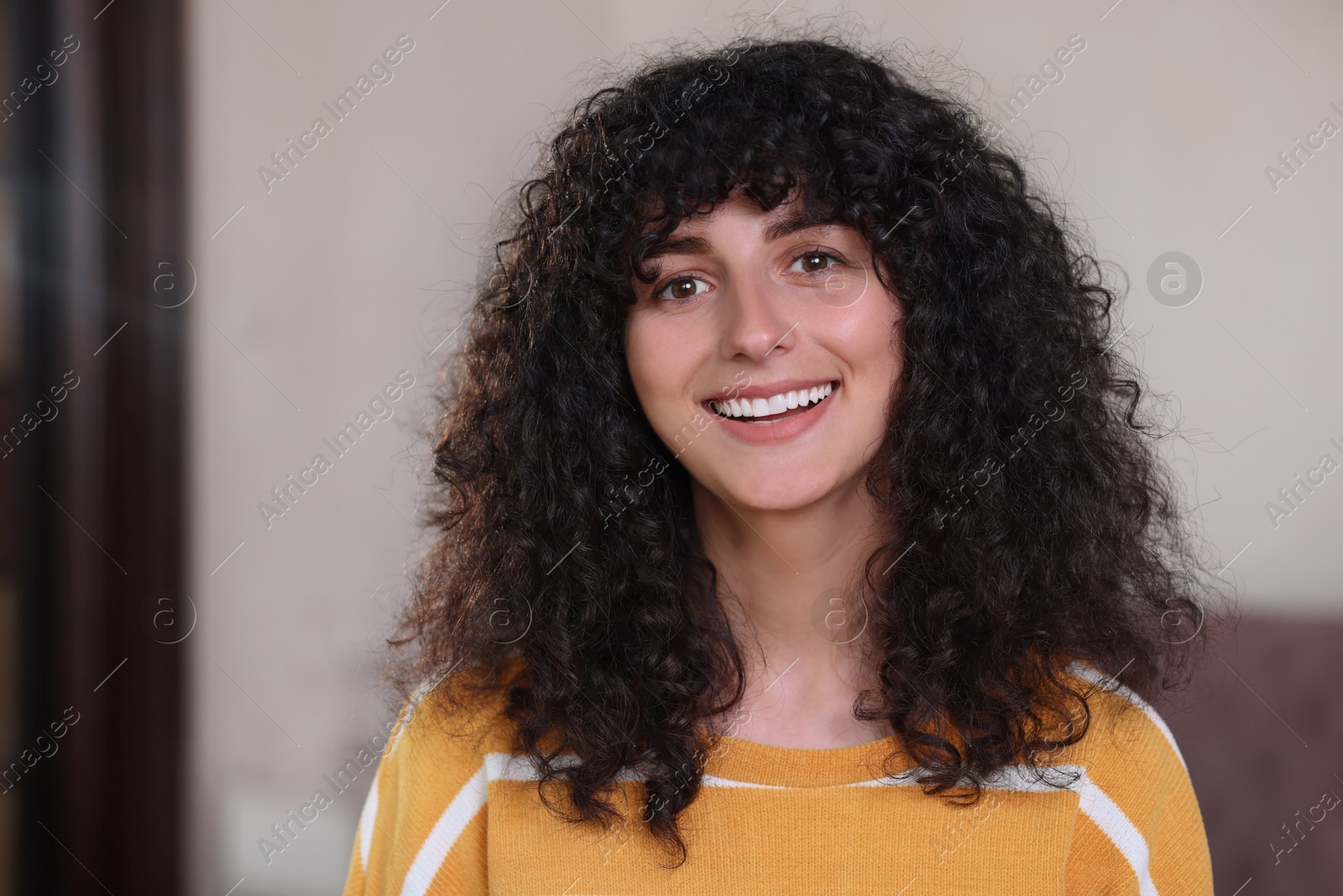 Photo of Portrait of happy young woman in stylish sweater indoors