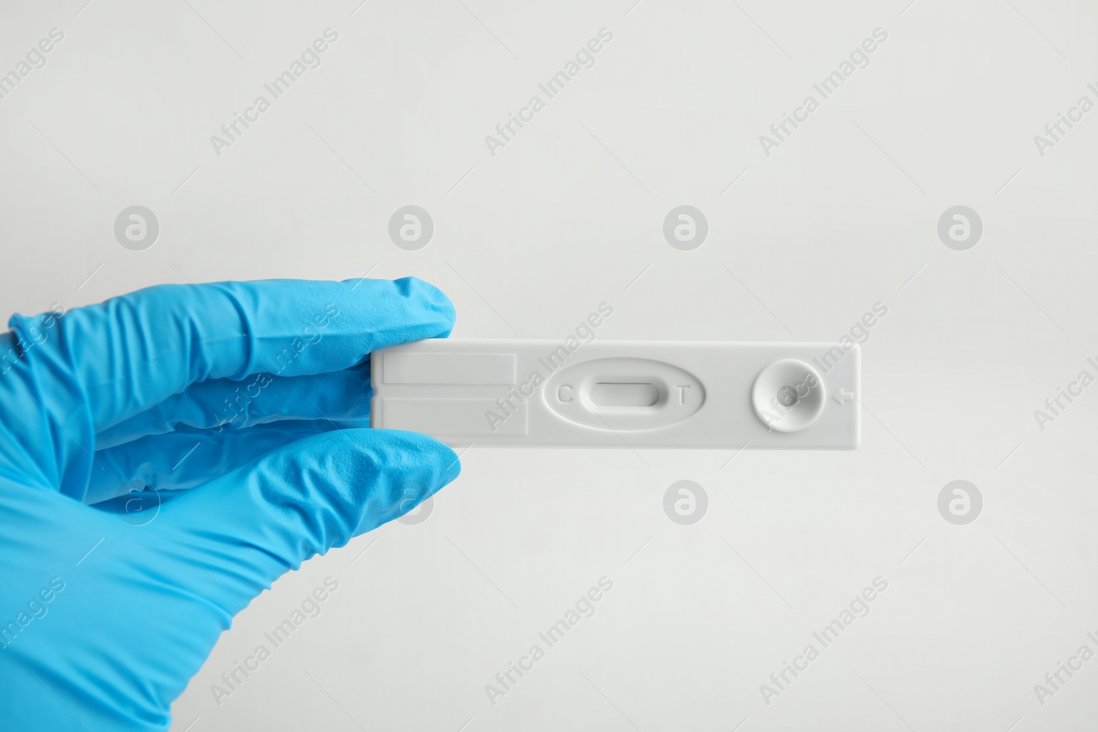 Photo of Doctor holding disposable express test for hepatitis on white background, closeup