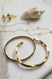Photo of Elegant bracelets, necklace and earrings on white table, closeup