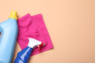 Photo of Microfiber cloth and detergents on beige background, flat lay. Space for text