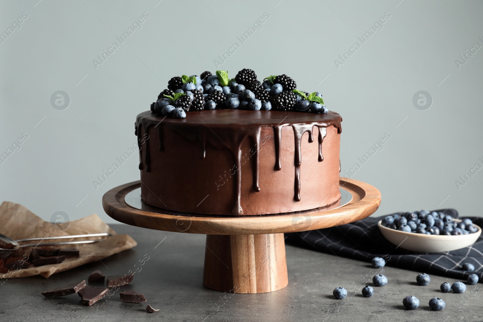 Photo of Fresh delicious homemade chocolate cake with berries on table against gray background