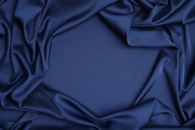 Photo of Crumpled dark blue silk fabric as background, top view. Space for text