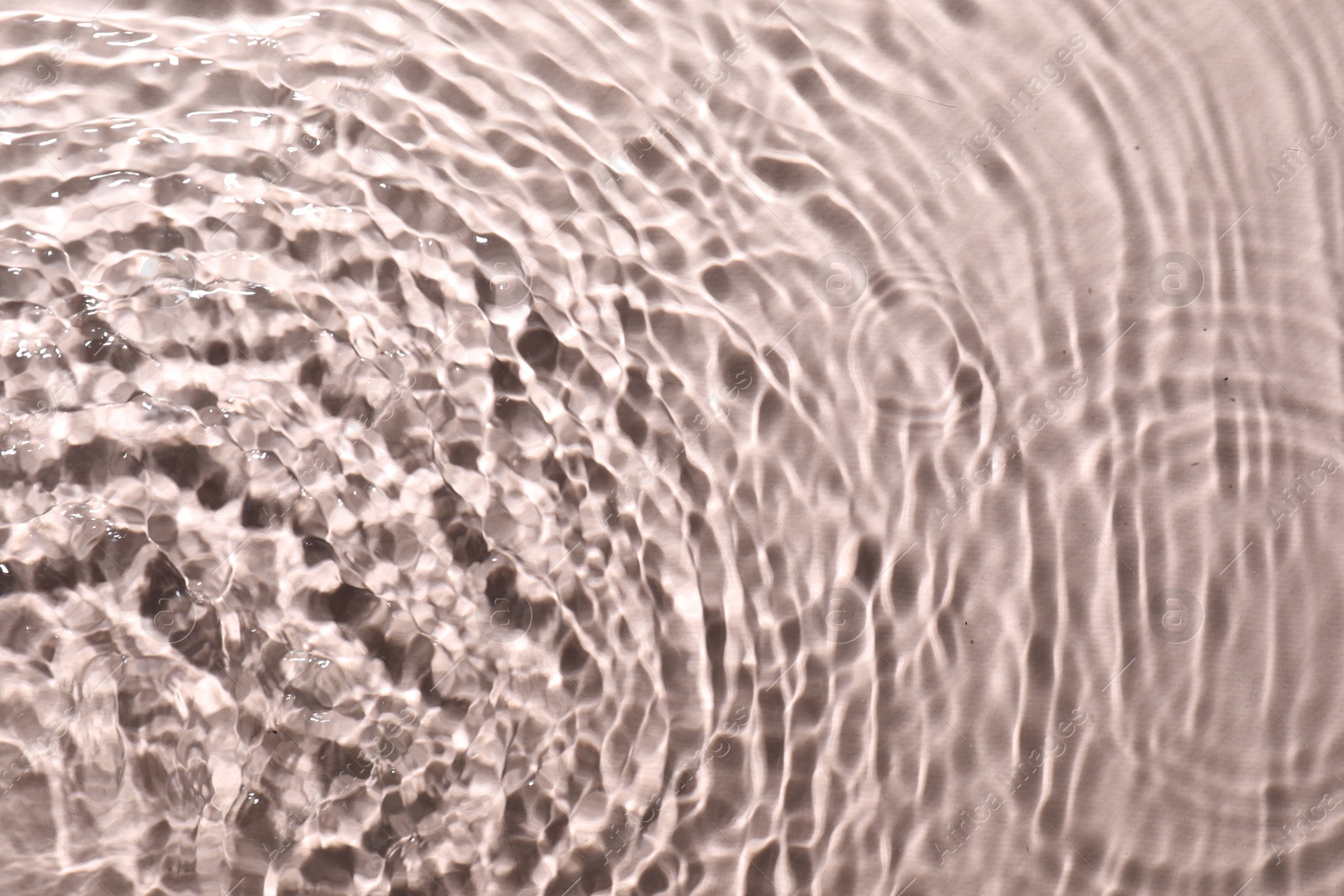 Photo of Rippled surface of clear water on beige background, top view