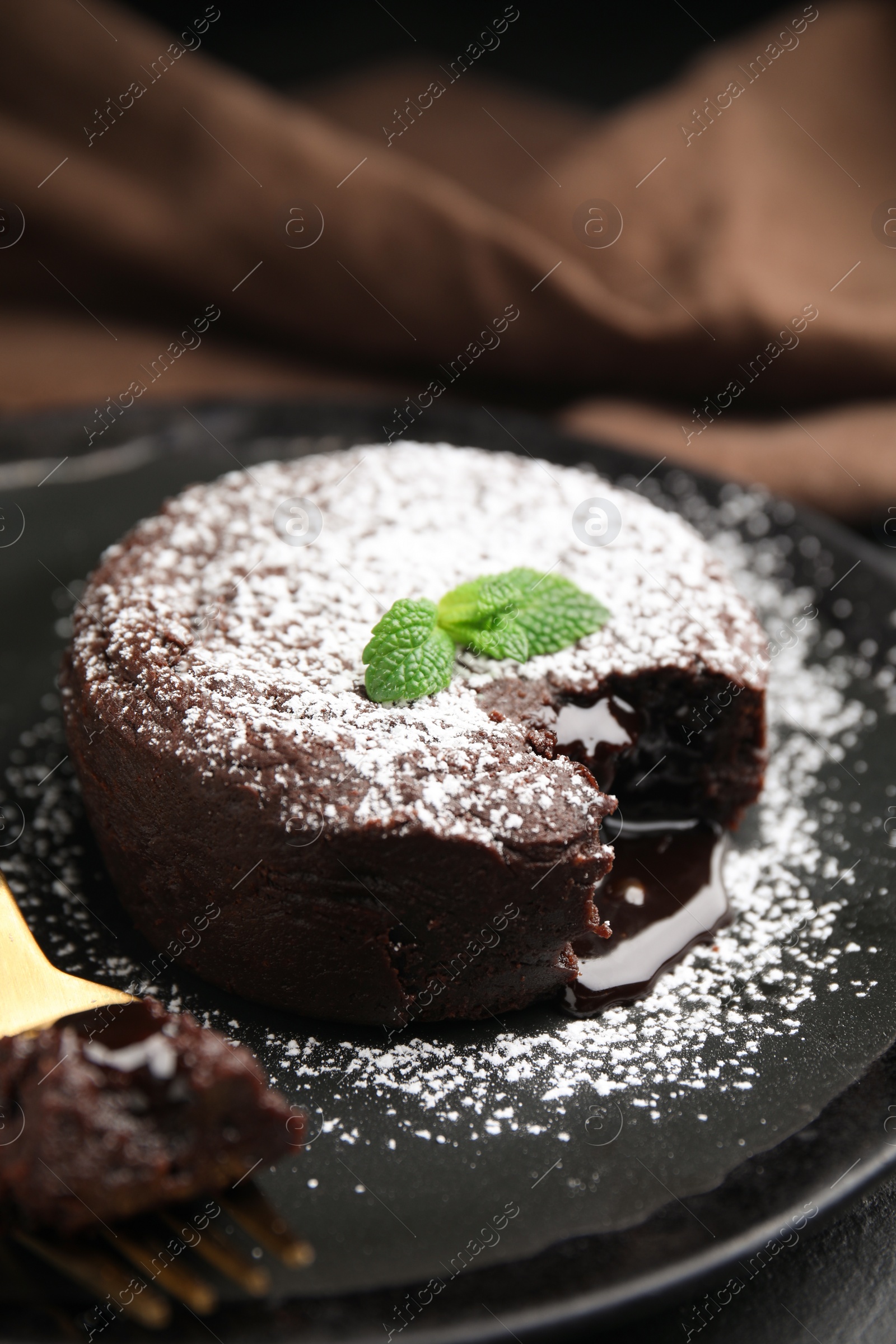 Photo of Delicious fresh fondant with hot chocolate and mint on black table, closeup