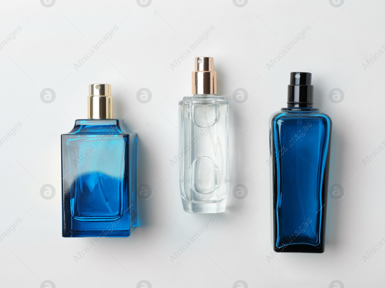 Photo of Transparent bottles of perfume on white background