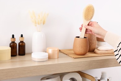 Bath accessories. Woman with brush indoors, closeup