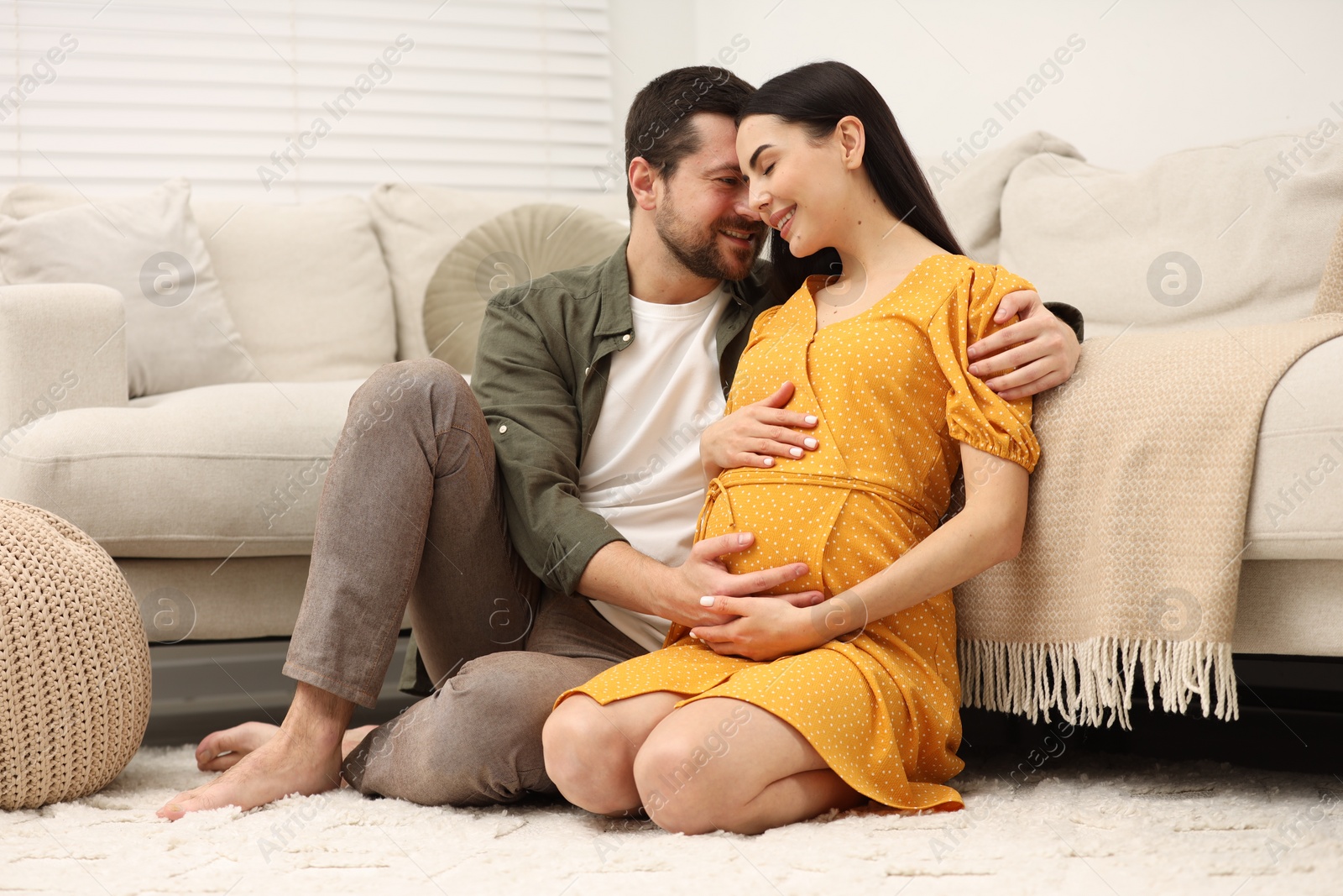 Photo of Happy pregnant woman spending time with her husband at home