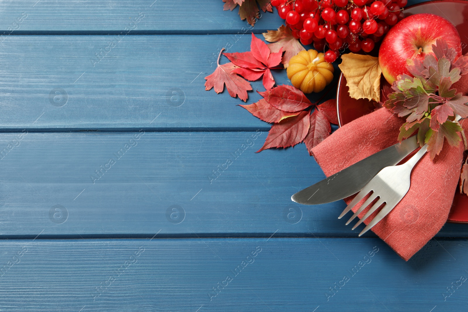 Photo of Festive table setting with autumn decor on blue wooden background, flat lay. Space for text