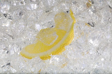 Juicy lemon slice and ice cubes in soda water against white background, closeup