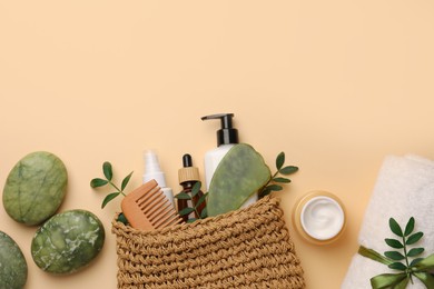 Photo of Preparation for spa. Compact toiletry bag with different cosmetic products, sea salt and towel on beige background, flat lay. Space for text