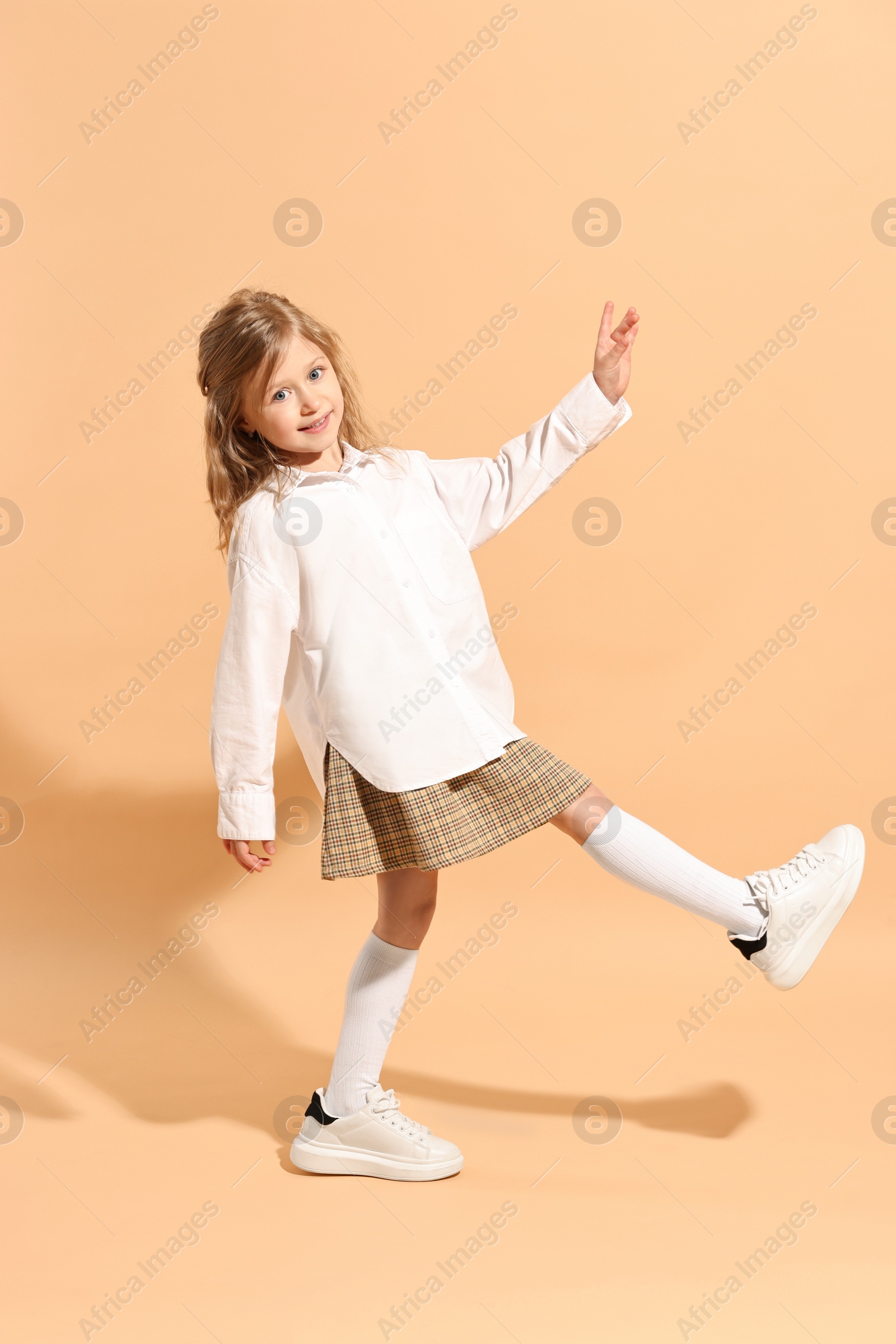 Photo of Fashion concept. Stylish girl on pale orange background