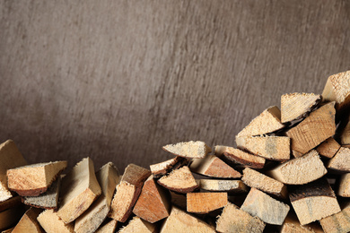 Cut firewood on brown background. Space for text