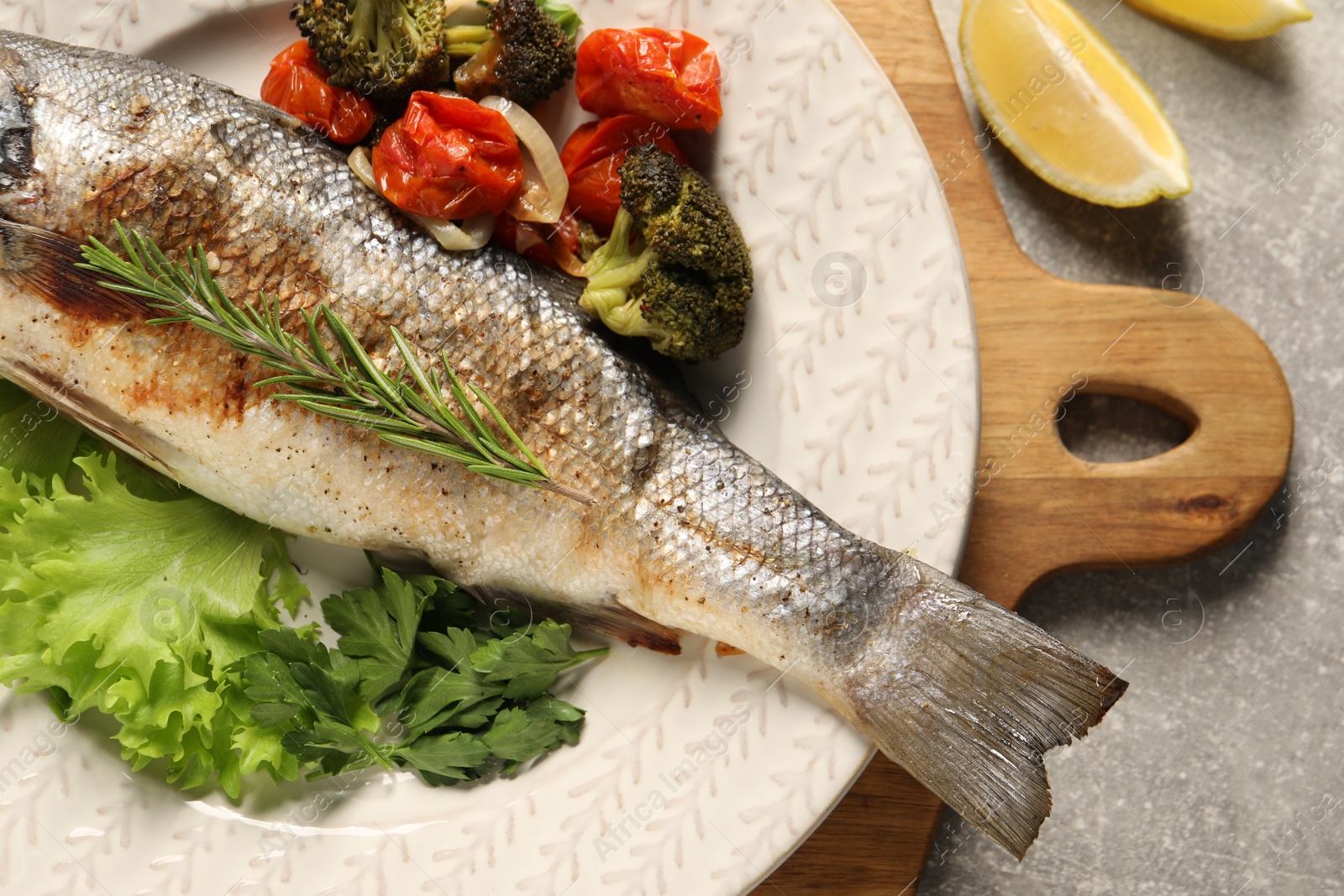 Photo of Delicious baked fish and vegetables on light grey table, top view