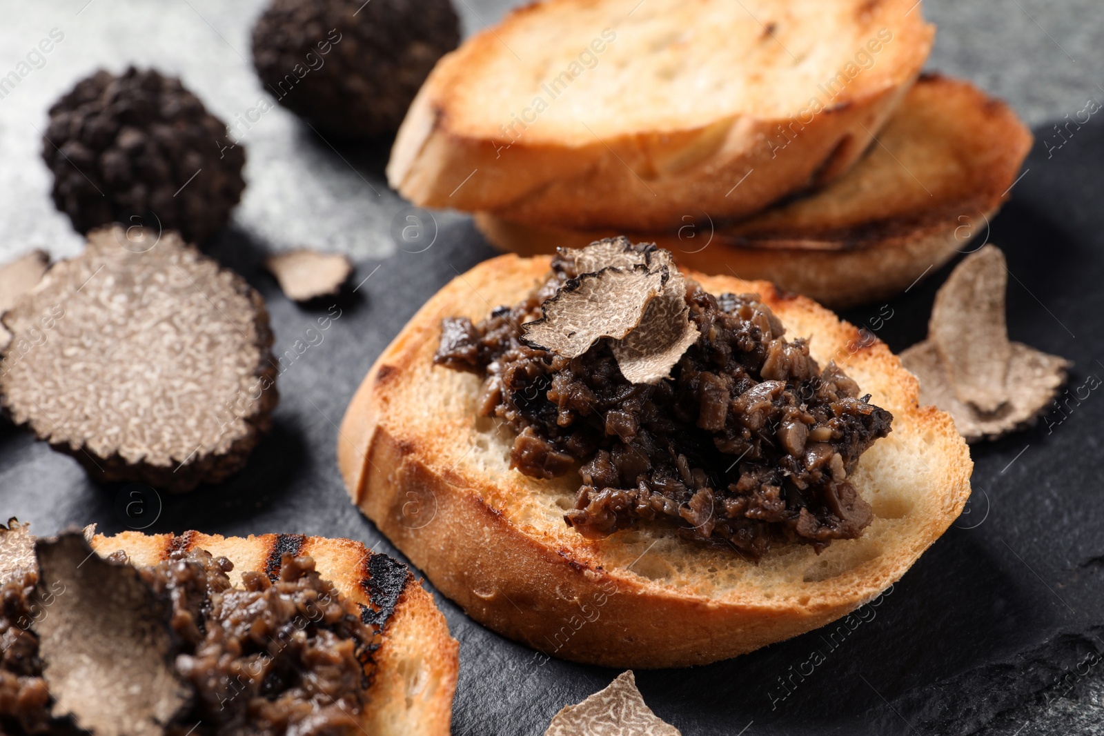 Photo of Delicious bruschetta with truffle sauce on grey table, closeup