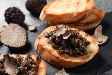 Photo of Delicious bruschetta with truffle sauce on grey table, closeup