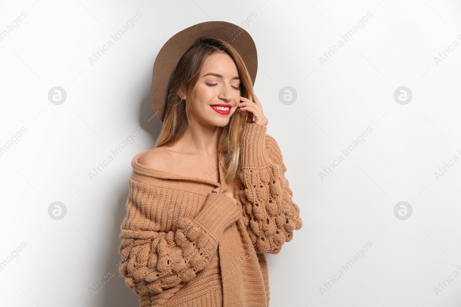 Photo of Beautiful young woman in warm sweater with hat on white background. Space for text