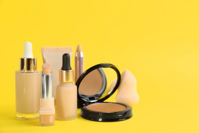 Photo of Foundation makeup products on yellow background, space for text. Decorative cosmetics