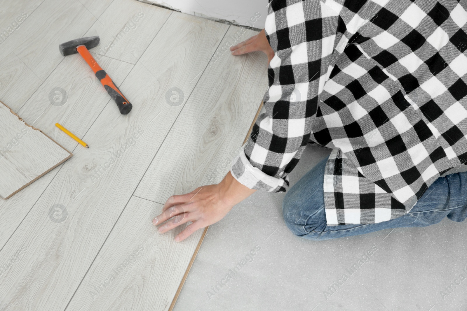 Photo of Professional worker installing new laminate flooring, closeup