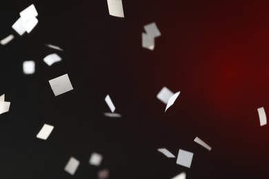 Photo of White confetti falling down, toned in red