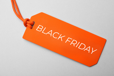 Tag with text BLACK FRIDAY on light background, top view