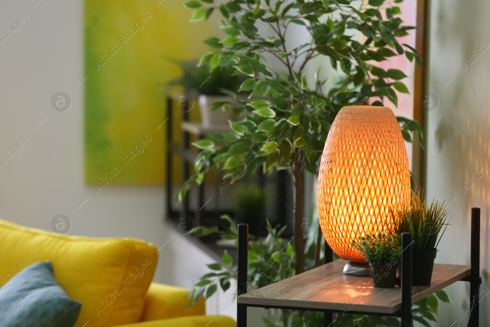 Photo of Stylish lamp on table in living room. Interior design element