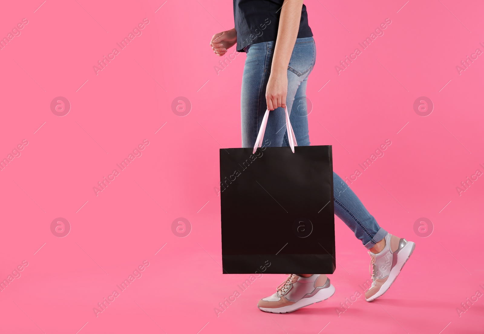 Photo of Woman with paper shopping bag on color background. Mock up for design